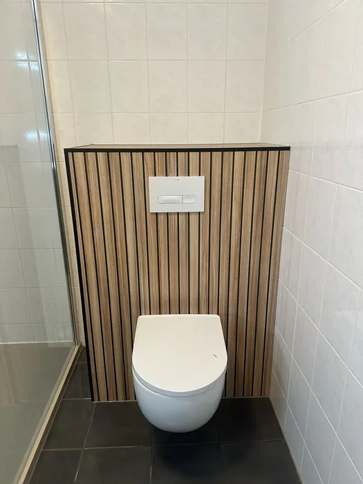 Hangtoilet voor een voorzetwand met houtlook lamellen tussen witte tegels