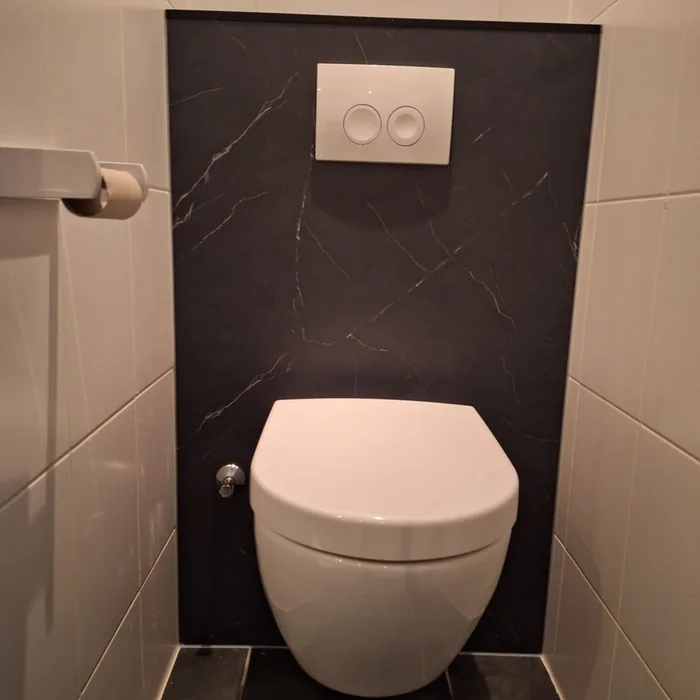 Hangtoilet voor een zwart marmerlook paneel met witte drukplaat