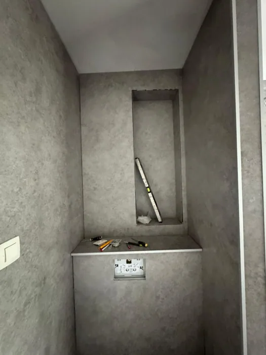 Voorzetwand met nis, al bekleed met grijze panelen, vlak voordat het toilet wordt gehangen